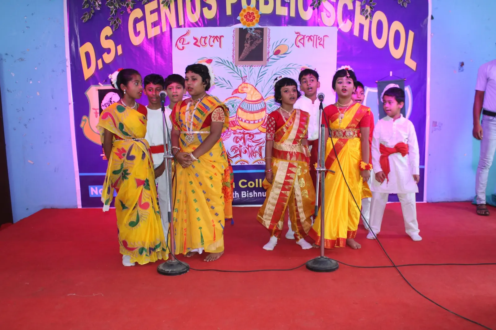Students of D.S. Genius Public School on stage during a cultural programme. This photograph is not the proposed construction site.